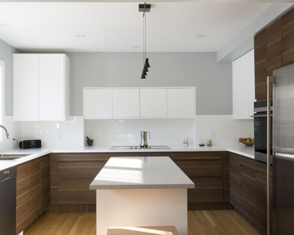 Modern kitchen renovation with natural light, warm woods and white uppers. Combining multi colored cabinets. 