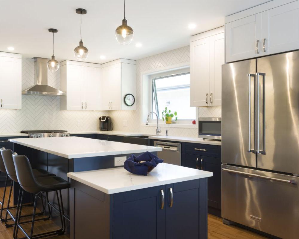 Bright kitchen featuring a large island, pendant lighting, and sleek two-tone cabinetry