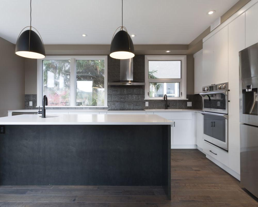Modern kitchen renovation with natural light, warm woods and white uppers. Combining multi colored cabinets. 