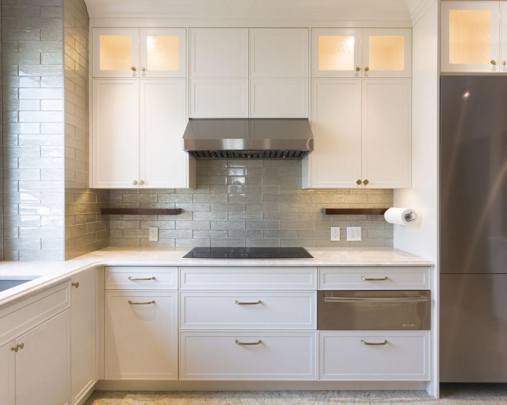 Luxury kitchen with stainless steel appliances, white cabinetry, and modern hardware finishes
