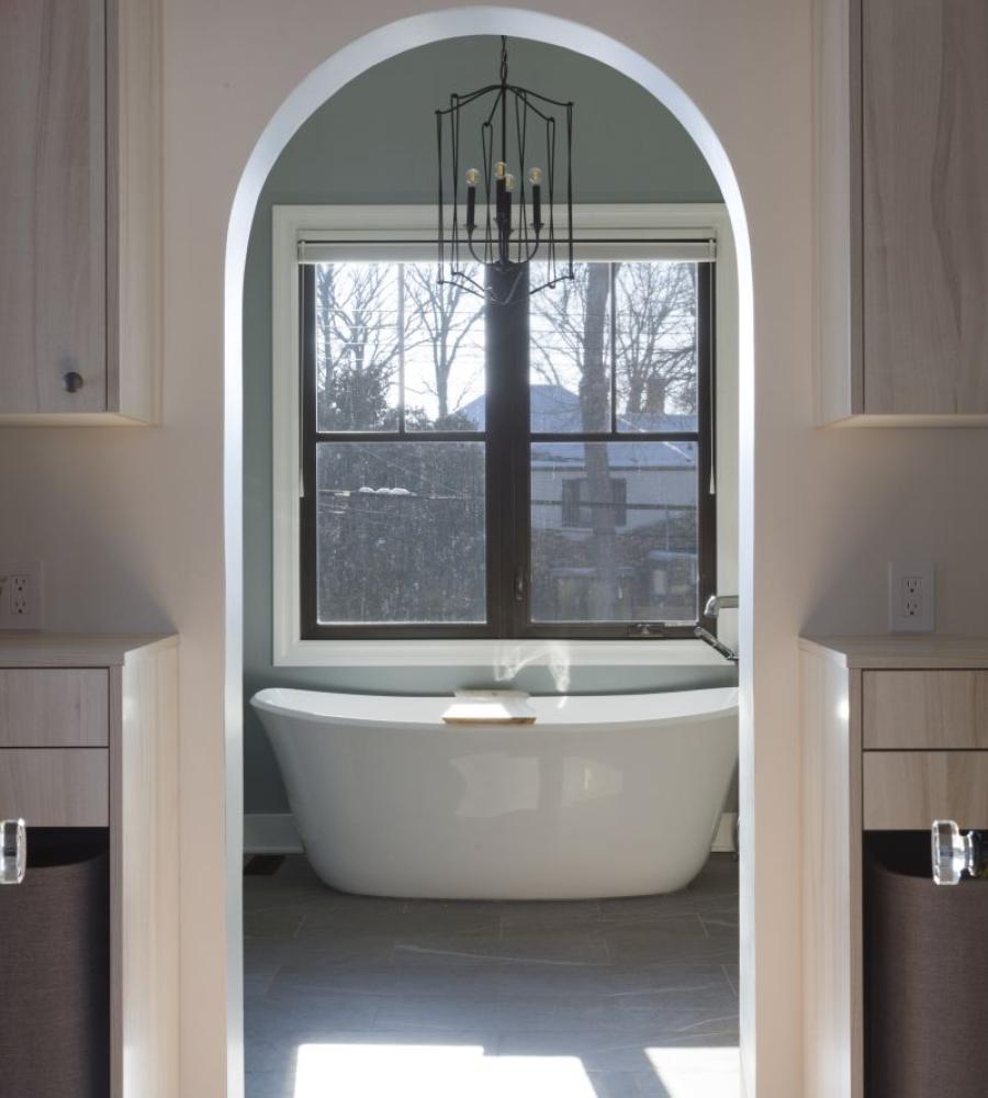 Arched bathroom entry with large white tup