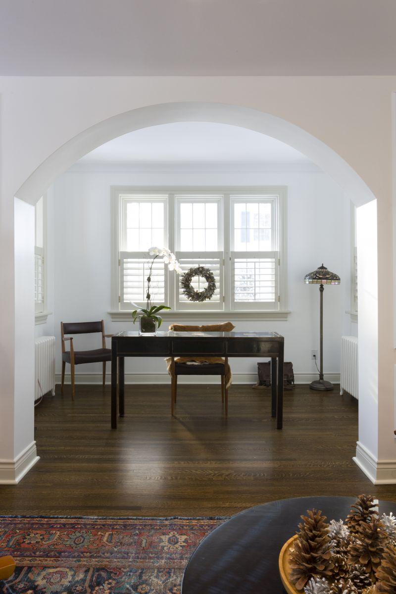 Custom home office with wall moulding and arched entry